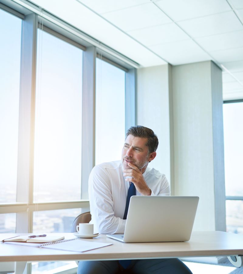 Mature business leader in a modern office thinking and looking to the side